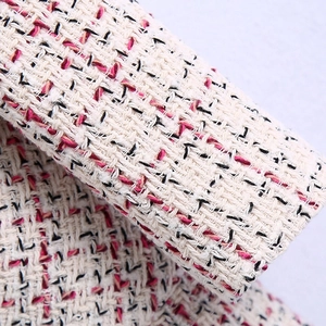 Close-up of premium tweed fabric texture showing cream, pink, and black woven fibers