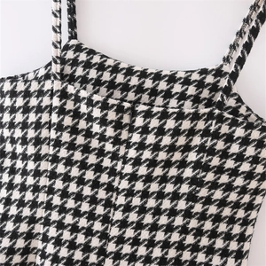 Detail of houndstooth tweed dress featuring slim straps and a hidden front zipper