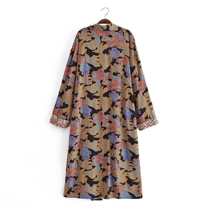 Detail of kimono cardigan with floral patterns and leopard print cuffs on wooden hanger