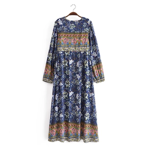 Detail of bohemian V-neck dress featuring floral patterns and tassel drawstring accents