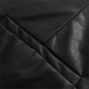 Close-up of black PU leather skirt featuring detailed lychee grain texture and fine stitching