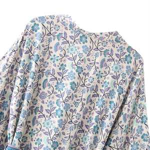 Gros plan du tissu fleuri sur robe col en V avec fleurs bleues et violettes