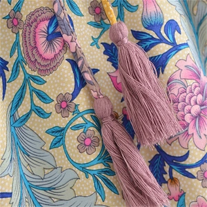 Close-up of cotton maxi skirt featuring floral print and decorative pink tassels