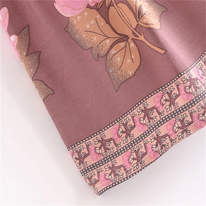 Close-up of floral cotton skirt featuring pink blossoms and intricate tassel lace hem detailing