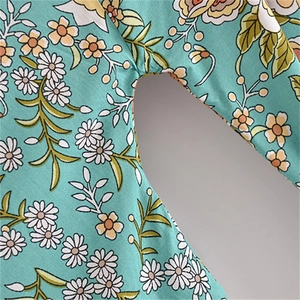 Detailed close-up of stitching and floral print on turquoise rayon kimono dress