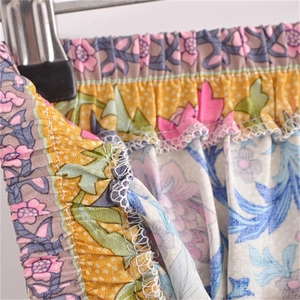 Macro detail of elastic waist and white overlock stitching on floral cotton maxi skirt