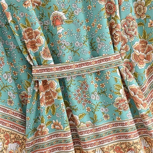 Detailed macro view of mint green floral rayon fabric with a bohemian tie waist belt