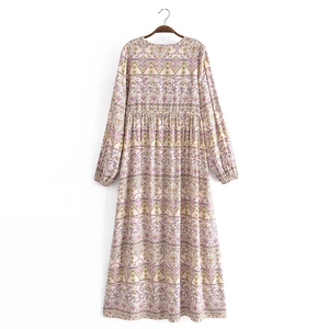 Detail of bohemian V-neck dress with purple floral patterns and delicate pleated waistline