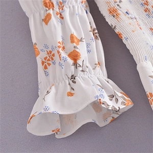 Détail de la manche bouffante florale avec taille froncée et motif à fleurs orange