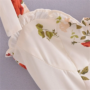 Close-up of red floral print and ruffled trim on white French vintage midi dress
