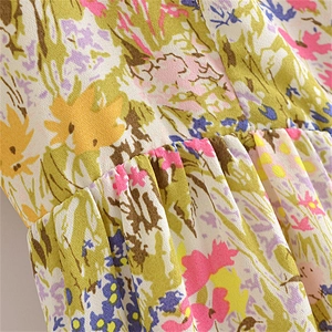 Close-up of gathered waist detail on a French floral chiffon dress with ink print