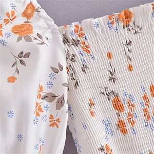 Détail de la texture élastique froncée sur robe florale avec motif de roses orange