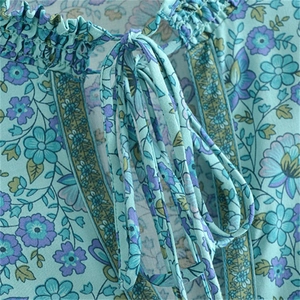 Détail de l'encolure en V à volants et imprimé floral bohème sur robe en coton menthe