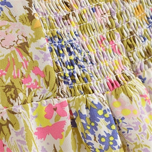 Detailed close-up showing smocking technique on floral printed fabric with vibrant patterns