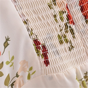 Detailed macro view of the elastic shirring and vintage floral print on a summer dress