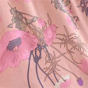 Close-up of floral print on peach cotton fabric with pink and purple flower patterns