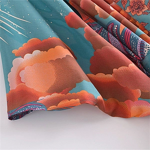 Detailed view of bohemian paisley print on blue rayon fabric with flowing texture