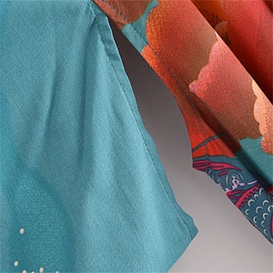 Macro detail of patterned viscose fabric with intricate stitching and floral print
