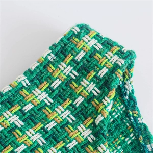 Vista macro dettagliata del tessuto in tweed verde e bianco del gilet con trama fine