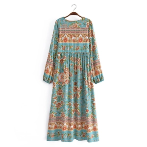 Détail de l'imprimé fleuri bohème sur robe longue bleue à manches longues et col rond
