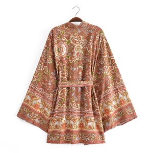 Dettaglio di un cardigan kimono boho con stampa floreale rossa e cintura in vita