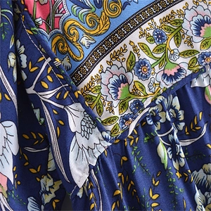 Close-up of bohemian floral print fabric and detailed stitching on the V-neck dress