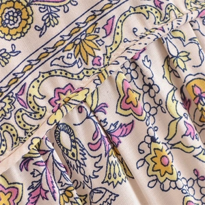 Detail of bohemian floral print fabric with precision stitching and pleated texture