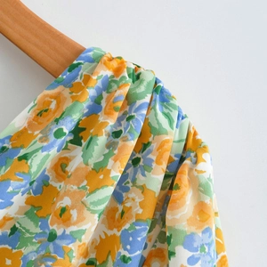 Detailed view of elastic pleated shoulder with bright yellow and blue floral print