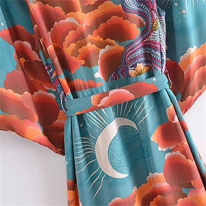 Bohemian style wrap kimono dress featuring sun and moon prints in teal and orange hues