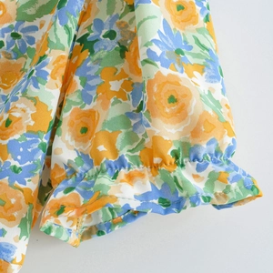 Close-up of elastic ruffle cuffs on a floral chiffon dress with blue and yellow flowers