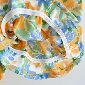 Detailed macro view of elastic smocked cuff on a floral print mini dress for women