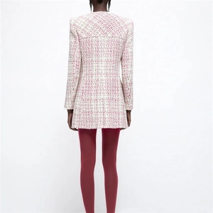 Rear view of white tweed long-sleeve jacket with padded shoulders and slim-fit texture