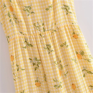 Détail de la robe à carreaux jaunes avec imprimé citron et taille froncée pour l'été