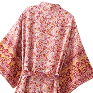 Dettaglio dell'abito kimono floreale rosa con stampa farfalle e bordi motivo cammello