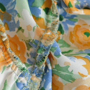 Macro detail showing neat overlock stitching on the floral print fabric of the dress