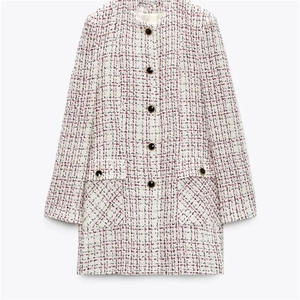 Detailed view of the tweed fabric texture and decorative gold-rimmed buttons on the coat