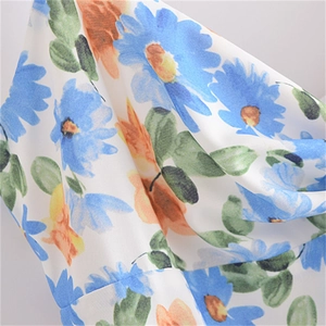 Gros plan du tissu en mousseline blanche avec imprimé floral de marguerites bleues