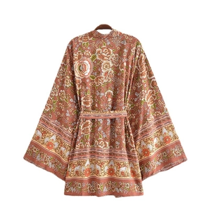 Abito kimono floreale bohémien con cintura e maniche larghe su sfondo bianco