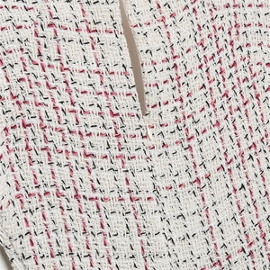 Détail du tissu en tweed texturé et de la fermeture éclair invisible sur la robe courte