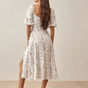 Détail du dos d'une robe fleurie avec manches bouffantes et fente élégante en bas