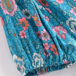 Detailed close-up of elastic ruffled cuffs on a blue bohemian floral print dress