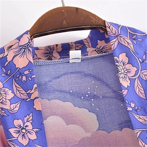 Détail de l'encolure du cardigan kimono montrant le motif floral et le tissu intérieur bleu