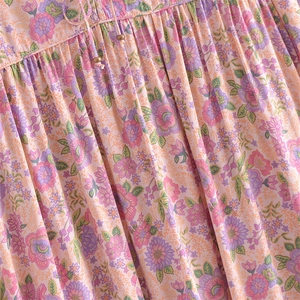 Detailed close-up of floral print fabric with pleats and drawstring tassel with metal beads