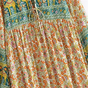 Détail de robe florale bohème avec lien à glands et imprimé chameau doré