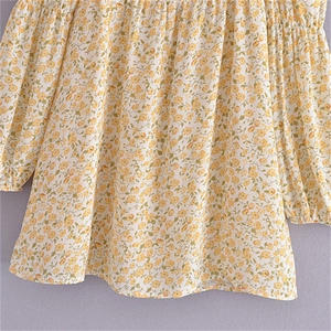 Detail of floral printed blouse with elastic ruched square neckline and long sleeves