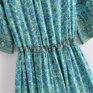 Detail of bohemian floral maxi dress featuring elastic waist and vibrant paisley pattern