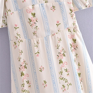 Détail de l'imprimé floral et des coutures de la robe à manches bouffantes blanc cassé