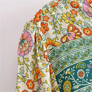 Détail de robe bohème montrant l'épaule plissée et l'imprimé floral éclatant