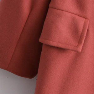 Classic double-breasted woolen coat in brick red with notched lapel and large pockets
