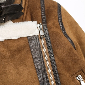 Detail of brown suede jacket showing shearling collar, metal zipper, and leather piping